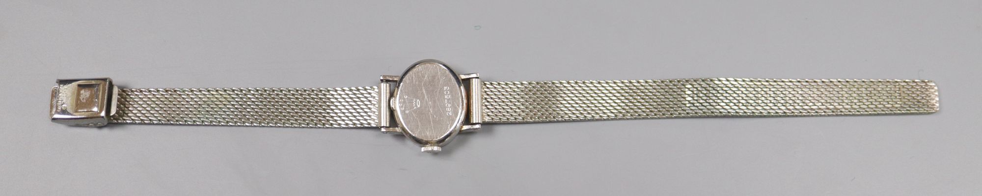 A ladys 18ct gold Rolex precision manual wind oval wrist watch, on a rhodium bracelet, overall 19cm, gross 26.8 grams.